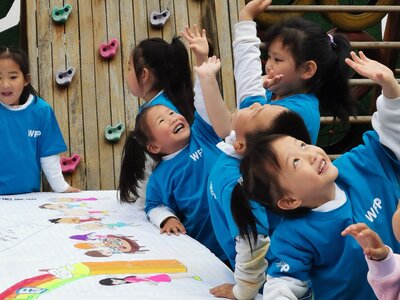 Photo: WFP/PMO Schoolchildren in WFP sweatshirts reaching upwards, in Xiangxi, Hunan Province of China