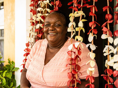 Photo: WFP/Gabrielle Menezes A Dominican woman laughing at camera in front of her house