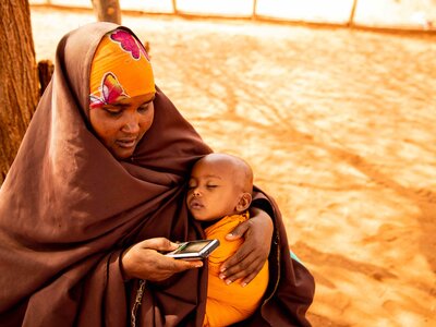 Photo: WFP/Gabrielle Menezes Malyun Abdullai Abdi receives mobile money to buy what she needs