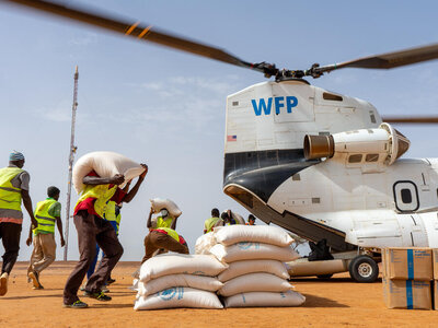 © WFP/Benoit Lognone Staff unloading bags of food assistance from a WFP heavy-duty helicopter