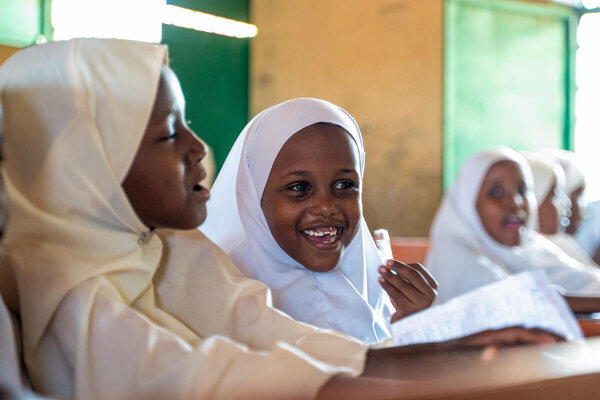 A classroom of smiling little girls in white headscarves. Photo: WFP_UNICEF/Arete/Ahmed Lusaka