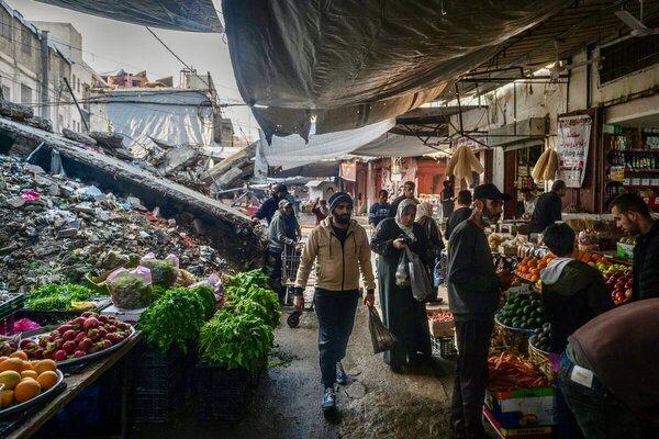 Men and women wearing long gowns and headdresses shop at an outdoor produce market in Gaza. Photo: WFP/Maxime Le Lijour