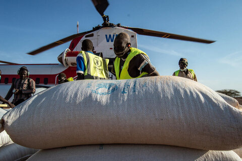 Bags of food from WFP are unloaded from a helicopter in Djibo, Burkina Faso, which is among Sahel countries where a confluence of climate change and conflict fuels hunger and displacement. Photo: WFP/Benoit Lognone 