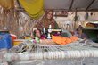 A woman whose livelihood was destroyed by flooding sews clothes