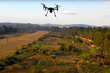 Drone flying over green terrain.