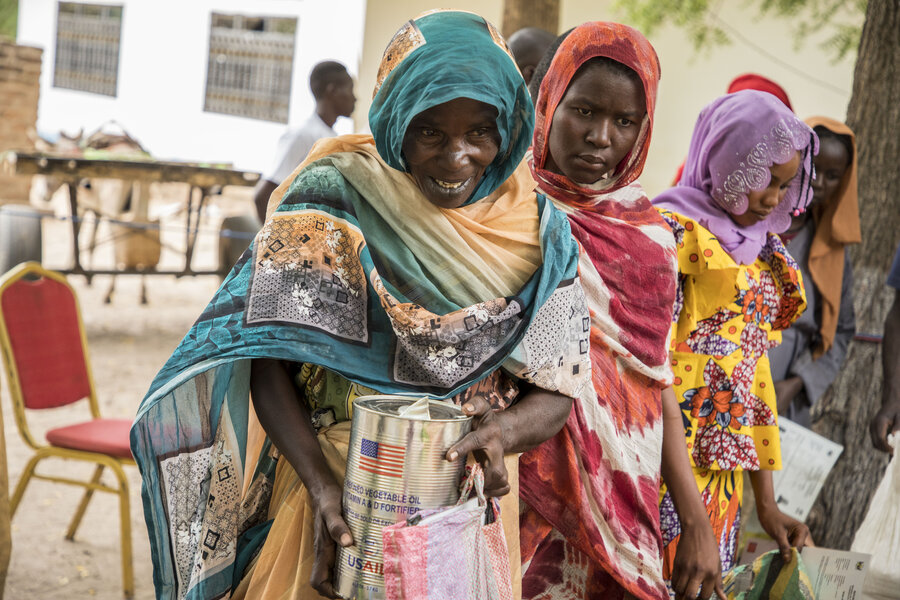Sudanese refugee Fordos collects fortified vegetable oil and other staples during a WFP food distribution in the Central African Republic town of Birao. Photo: WFP/Aurore Vinot