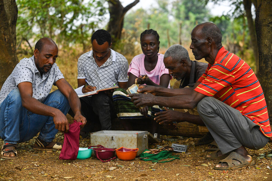 Farmer Belete Abate and members of his village and loan association in Abobo woreda, or administrative district, count their savings - which they used to buy their thresher, among other improvements. Photo: WFP/Michael Tewelde