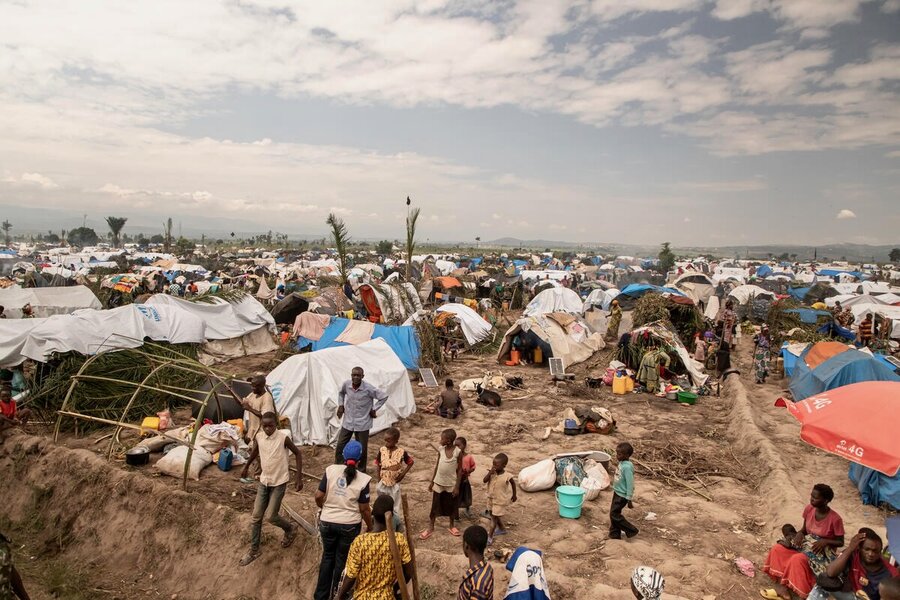 A tent camp and people outside under a cloudy sky. Photo: WFP/Irenee Nduwayezu