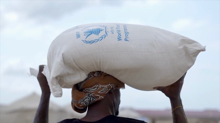 A closeup shot of man with a turban carrying a bag of WFP food assistance. Photo: WFP 