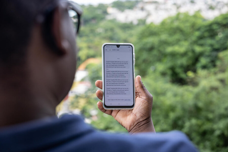 A man surveys early warning messages on his phone. Photo: WFP/Irshad Khan