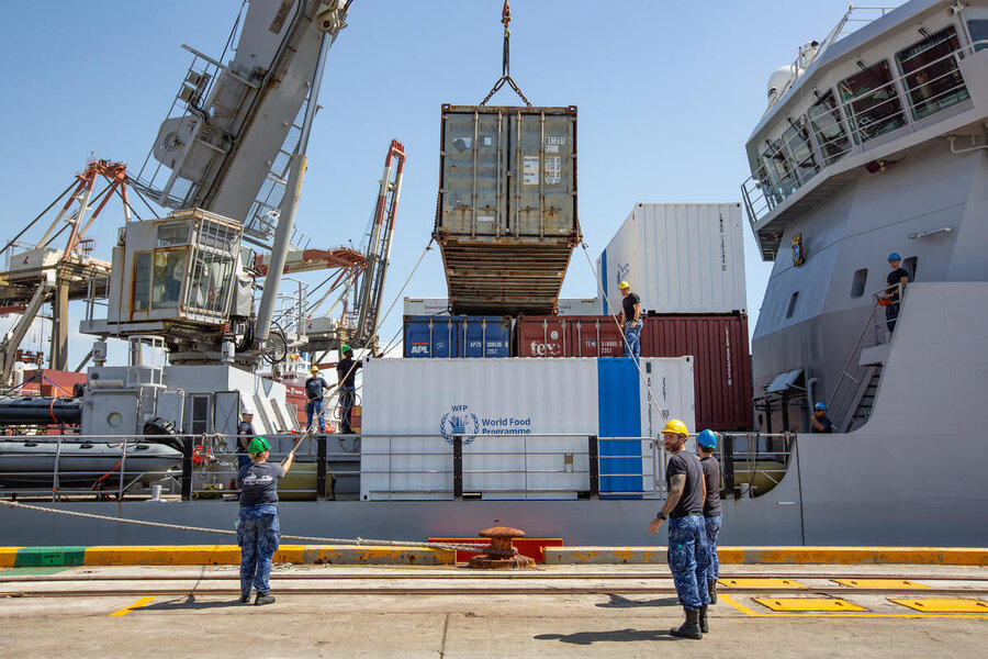 Workers survey WFP commodities being loaded onto a ship. Photo: WFP/Irshad Khan